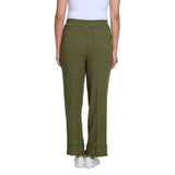 A model from the waist down wearing olive green wide-leg trousers with rolled cuffs, paired with a white top and white sneakers, against a plain white background.