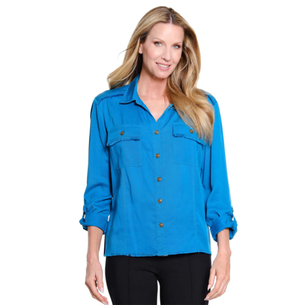 A woman modeling a bright blue long-sleeve button-up shirt with two chest flap pockets and brown buttons, paired with black pants, against a plain white background.