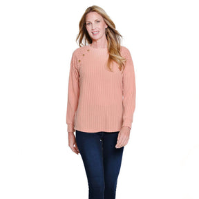 Woman wearing a light pink ribbed sweater and blue jeans on a white background