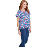 Woman wearing a blue floral top and jeans on a white background