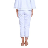 Person wearing a white outfit with lace details on a white background