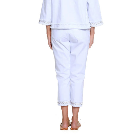 Person wearing a white outfit with lace details on a white background