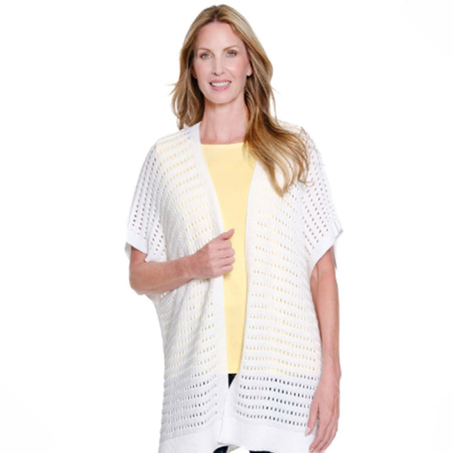 Woman wearing a white crochet cardigan over a yellow top on a white background