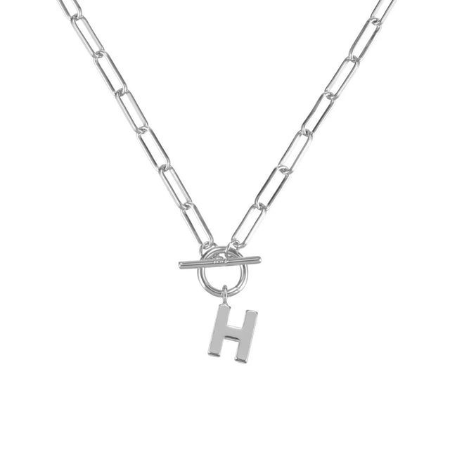 Silver necklace with a toggle clasp and 'H' charm on a white background