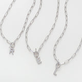 Three silver chain necklaces with letter pendants on a white background