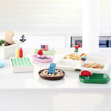 Colorful snack trays and bowls on a white surface with decorative items.