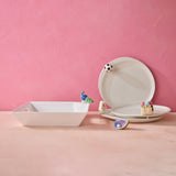 Ceramic plates and bowls with decorative elements on a pink background