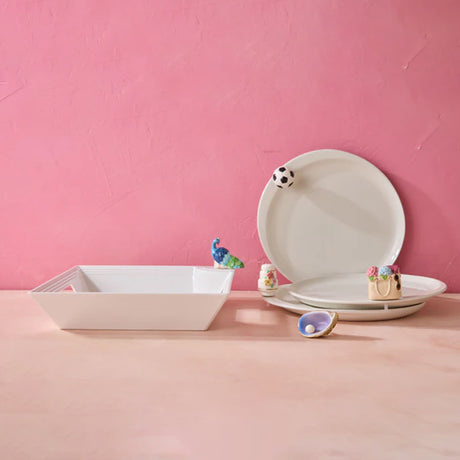Ceramic plates and bowls with decorative elements on a pink background
