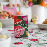 Small box with floral design and 'XOXO' text on a tablecloth with floral pattern