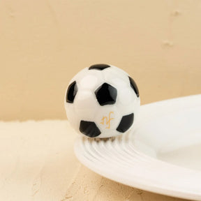 Soccer ball-shaped object on a beige surface