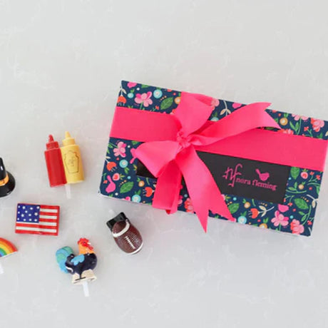Gift box with floral pattern and pink ribbon on a light gray background