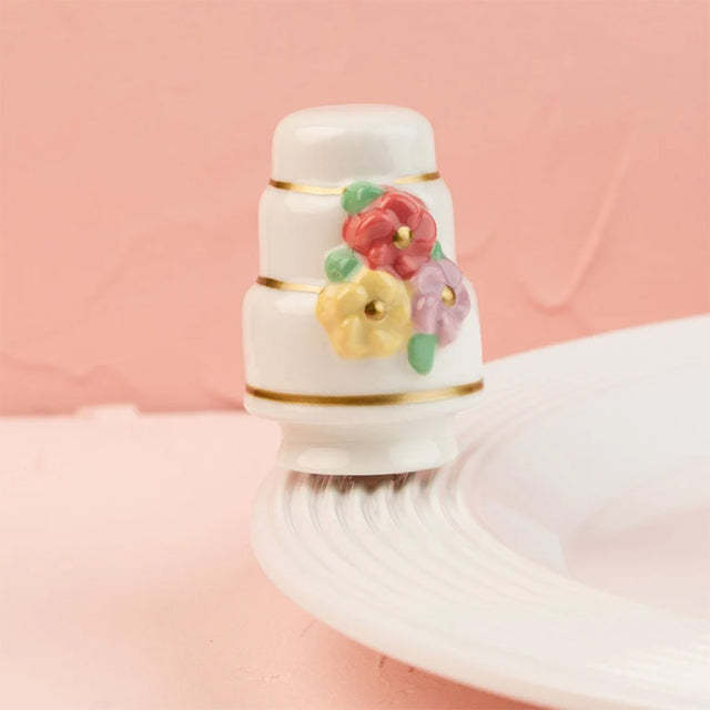 Decorative bottle cap with colorful flowers on a pink background