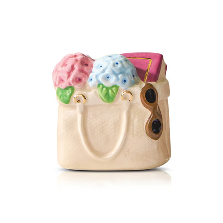 Decorative ceramic purse with floral designs on a white background