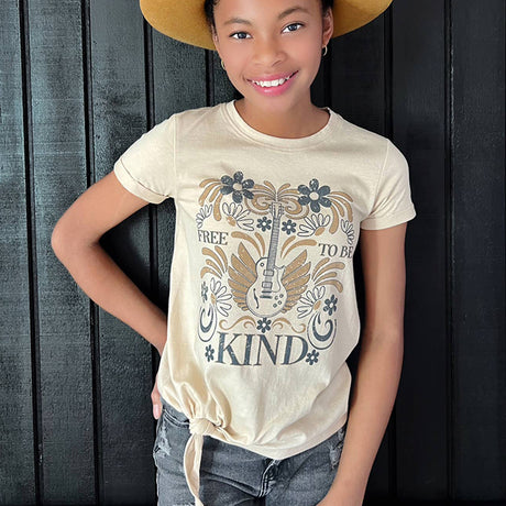 Child wearing a t-shirt with a graphic design and text, standing against a dark wooden panel background.