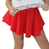 Red skirt with white lace trim worn by a person against a festive background