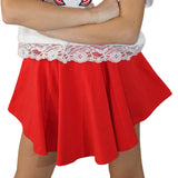 Red skirt with white lace top worn by a person against a festive background