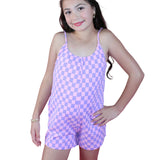 Girl wearing a pink and purple checkered romper against a white background
