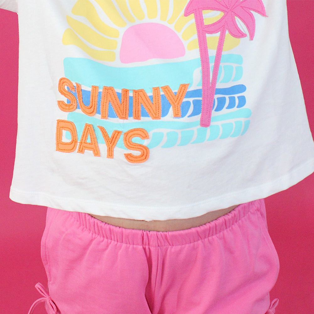White crop top with 'Sunny Days' text and palm tree design on a pink background