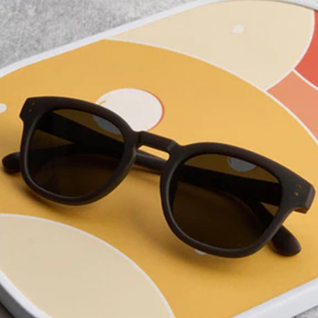 Black sunglasses on a colorful geometric-patterned surface