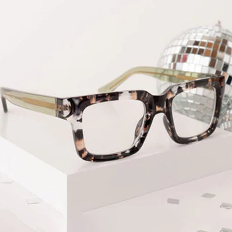 Tortoiseshell glasses with a disco ball on a white surface