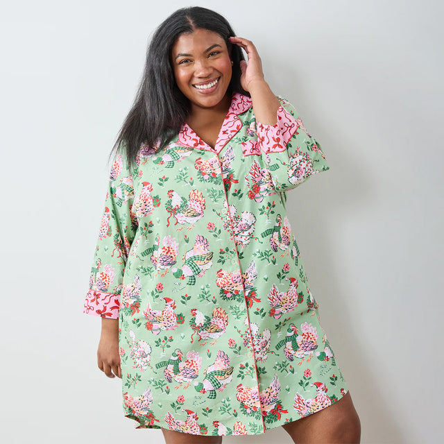 Woman wearing a floral nightshirt against a plain background