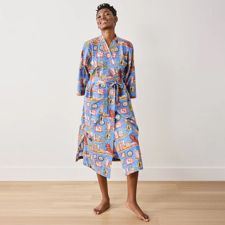 Person wearing a colorful robe with a pattern on a plain background