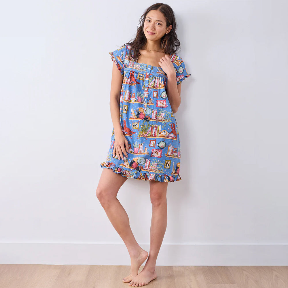 Woman wearing a colorful patterned dress against a white background