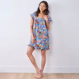 Woman wearing a colorful patterned dress against a white background