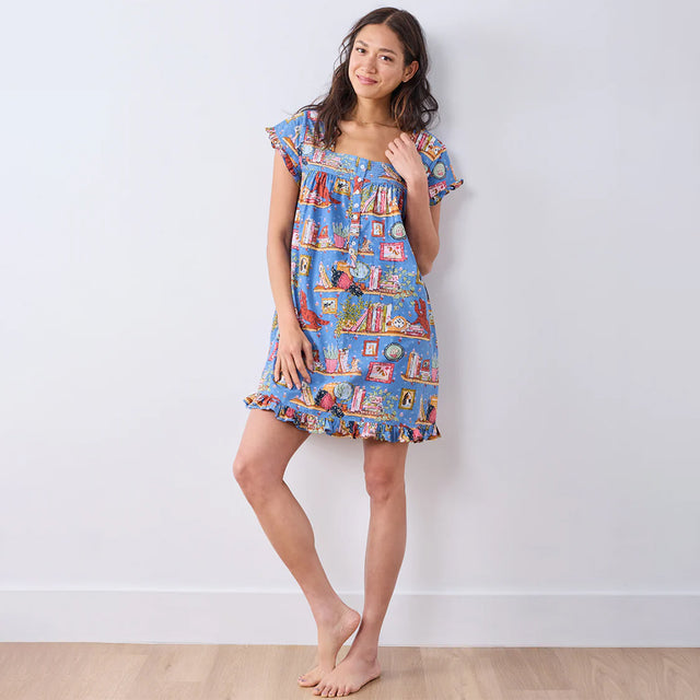 Woman wearing a colorful patterned dress against a white background
