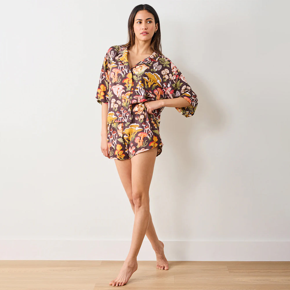 Woman wearing a floral patterned outfit on a plain background