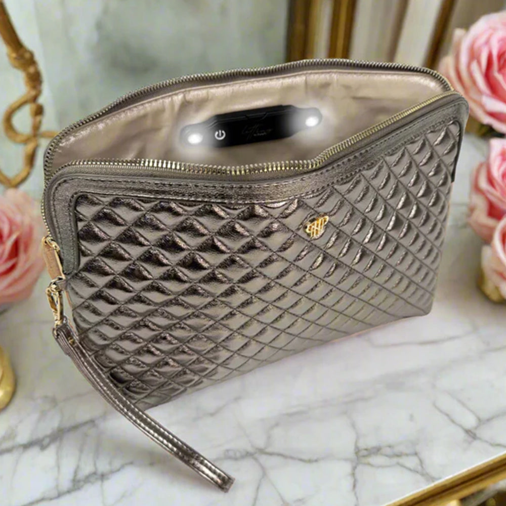 Quilted makeup bag on a marble surface with flowers in the background