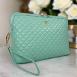 Quilted green handbag with a gold clasp on a light background