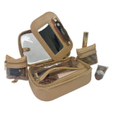 Open beige makeup bag with mirror and various cosmetic items on a white background