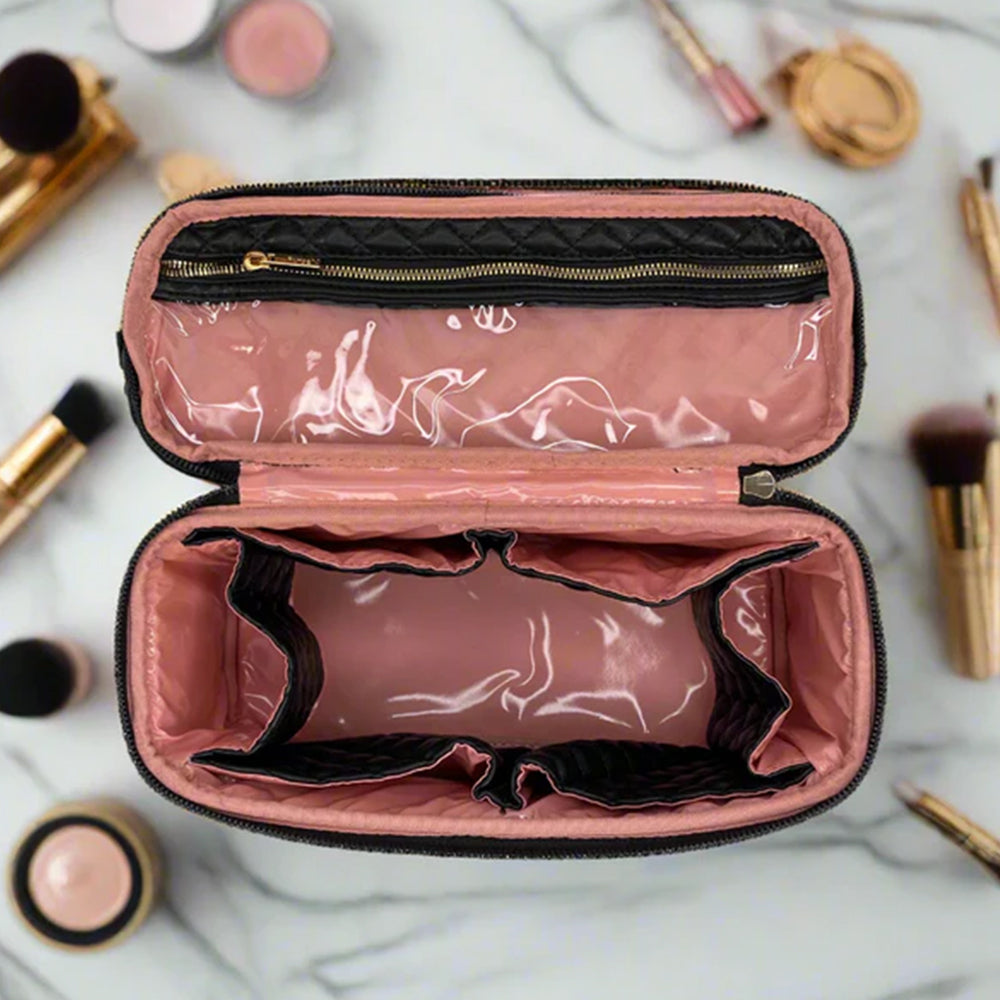 Pink makeup case with black interior on a marble surface with makeup items around