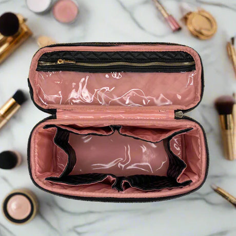 Pink makeup case with black interior on a marble surface with makeup items around