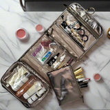 Open makeup bag with various cosmetic items on a marble surface