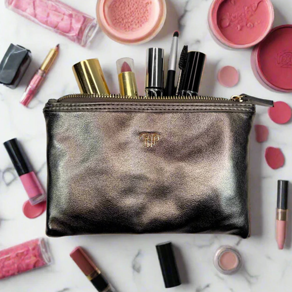 Makeup pouch with cosmetic products on a marble surface