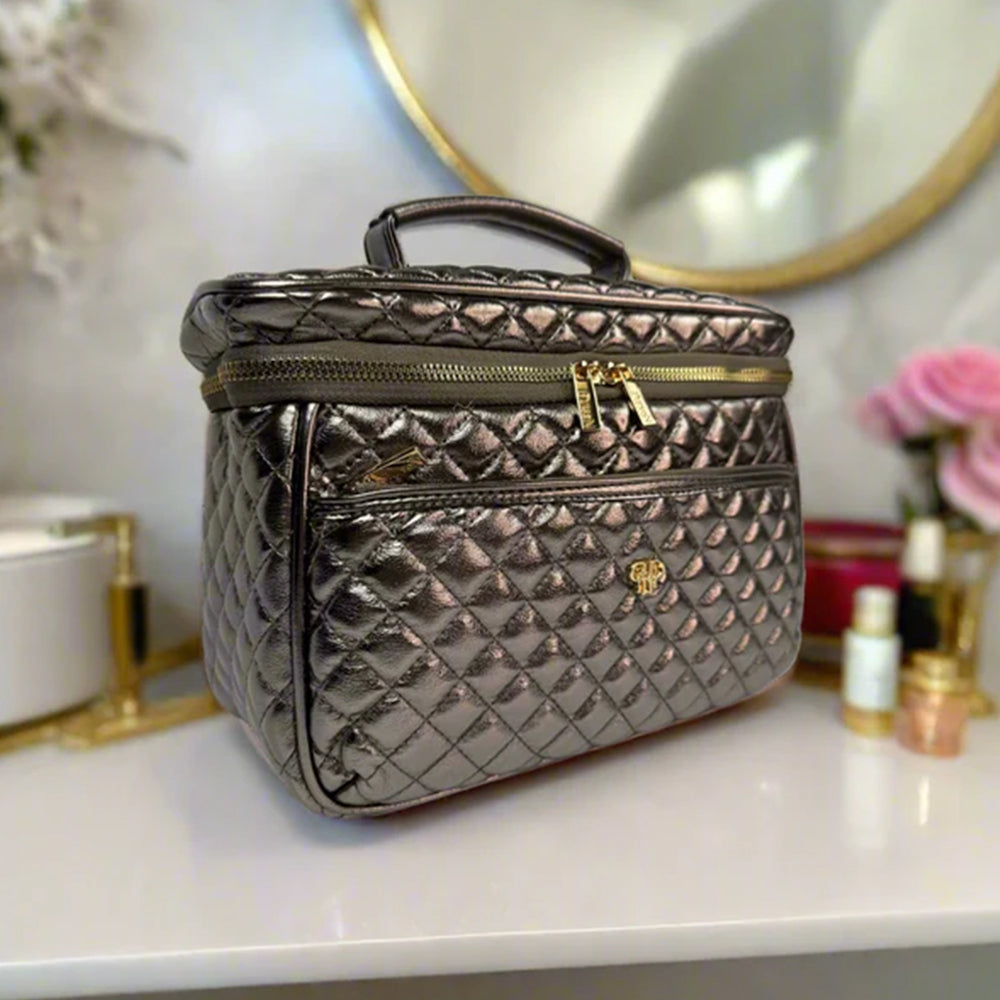 Quilted makeup bag on a vanity with decorative items in the background