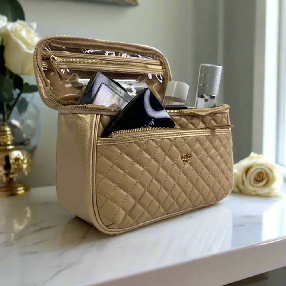 Quilted beige cosmetic bag with makeup items on a reflective surface