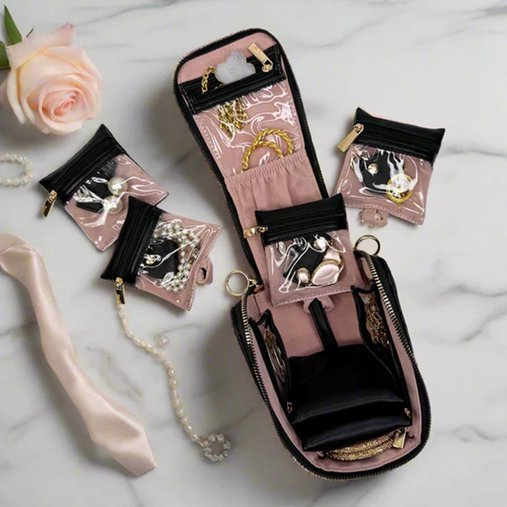 Jewelry organizer with necklaces on a marble surface with a rose.