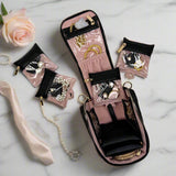 Jewelry organizer with necklaces on a marble surface with a rose.