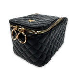 Black quilted bag with gold zipper and circular handles on a white background