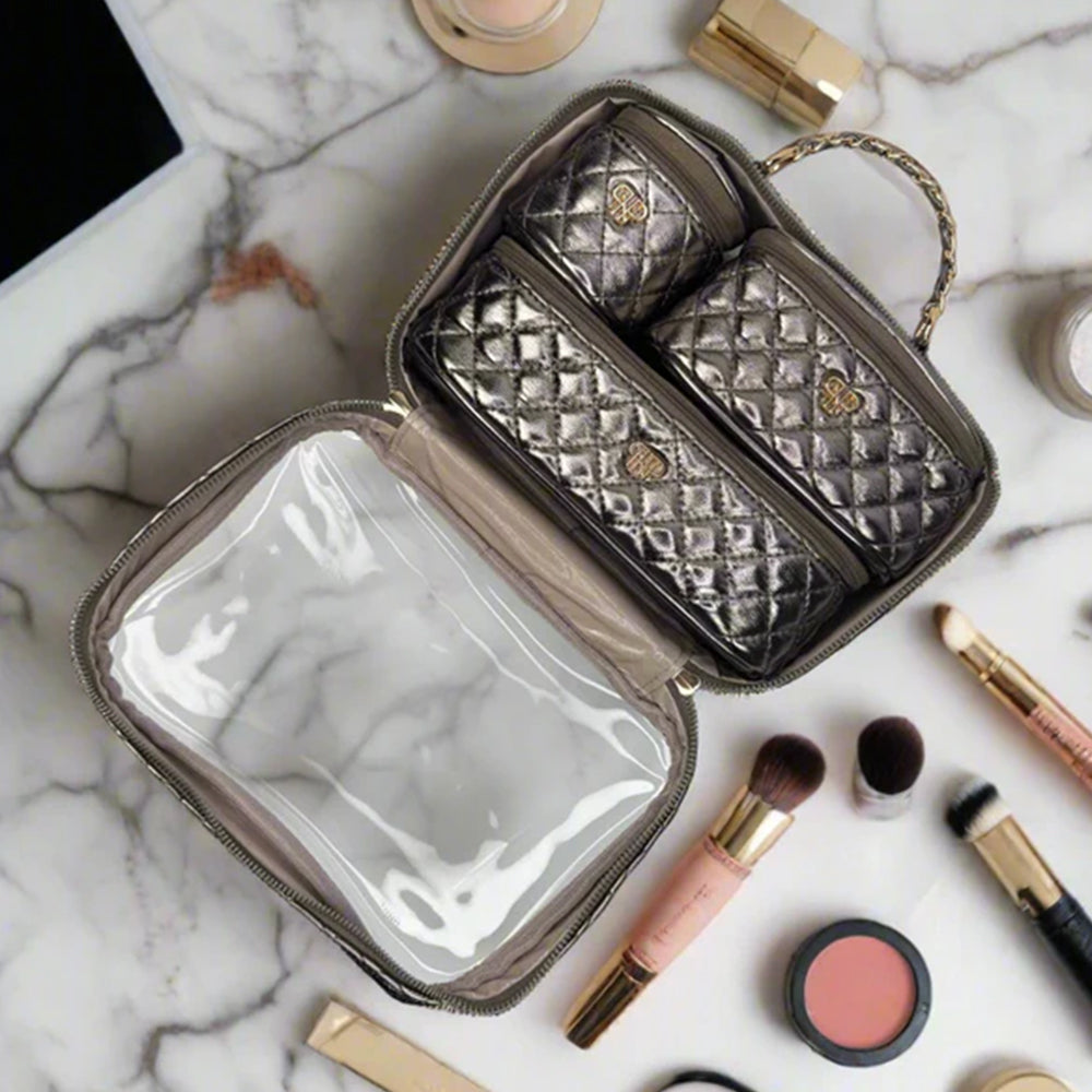 Quilted makeup case with cosmetic items on a marble surface