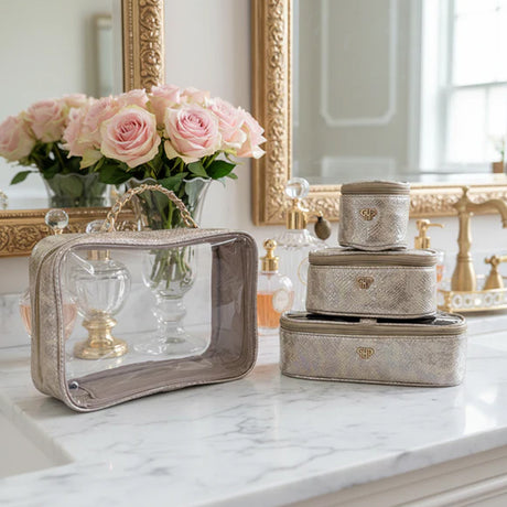 Set of decorative boxes on a marble surface with flowers and mirrors in the background