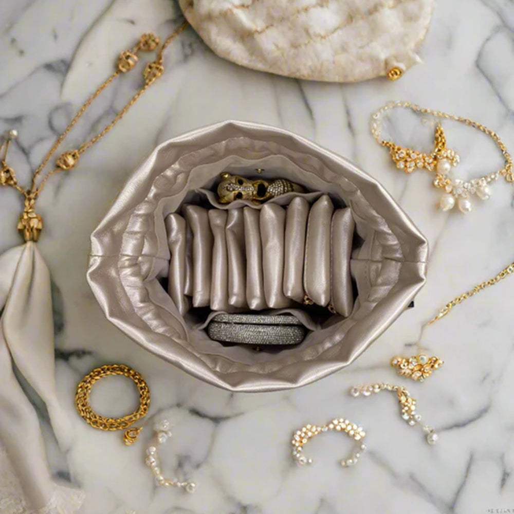 Jewelry set including necklaces, rings, and earrings displayed on a marble surface with a jewelry case.