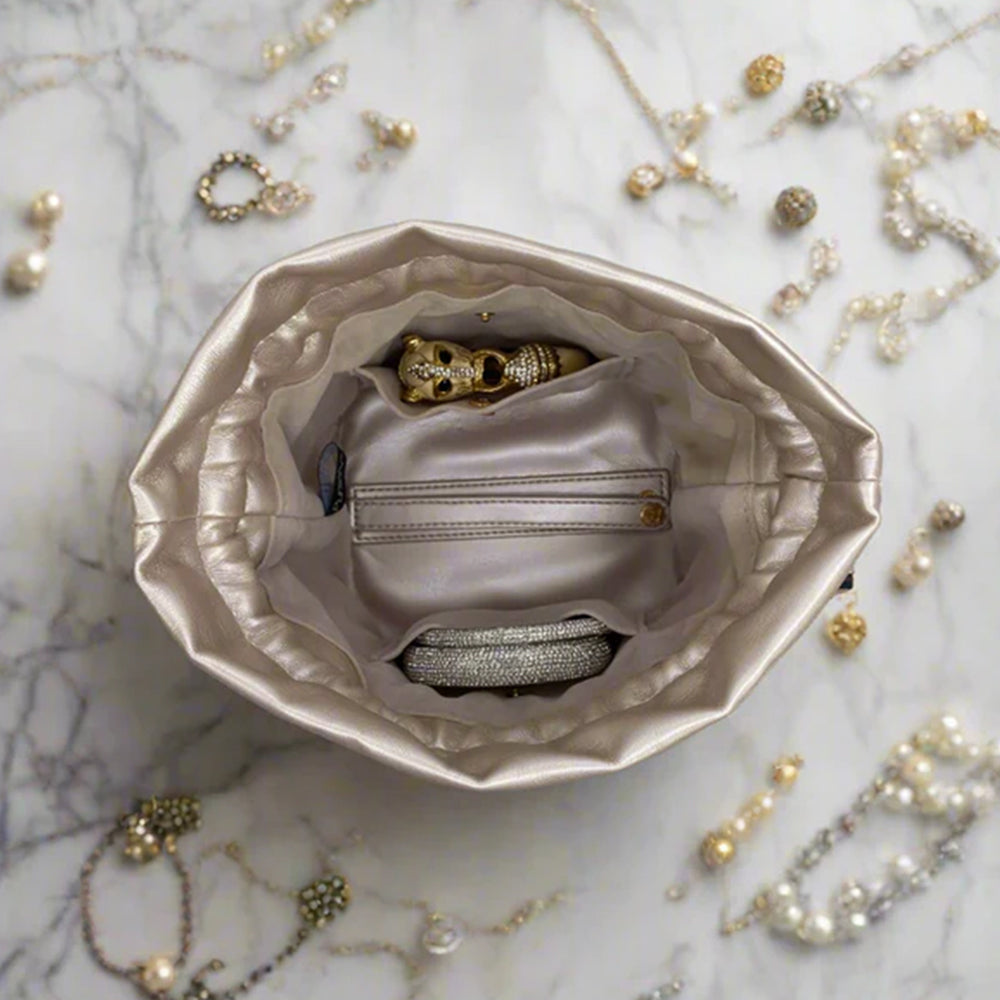 Silver jewelry box with gold and silver jewelry on a marble surface