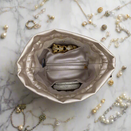 Silver jewelry box with gold and silver jewelry on a marble surface
