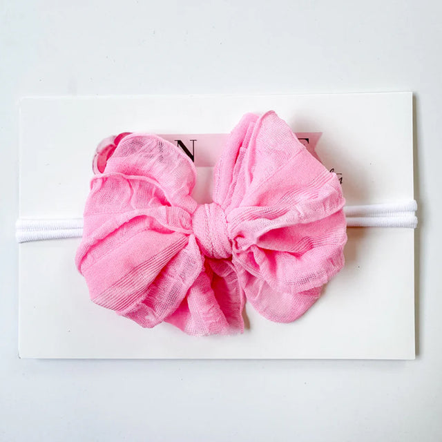Pink bow headband on a white background