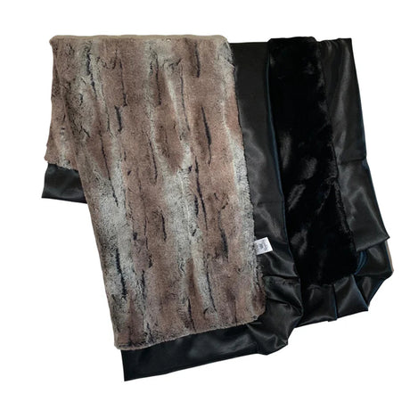 Folded fur blanket with brown and black pattern on a white background