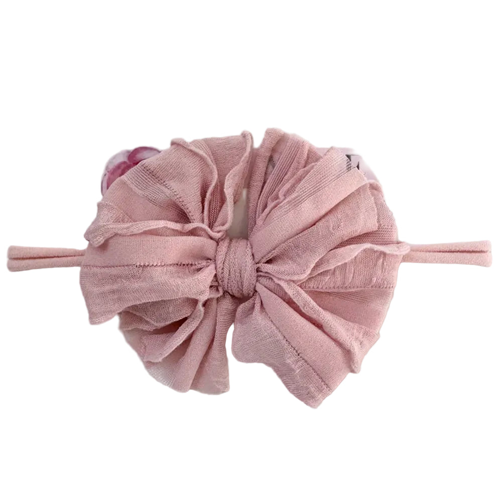 Pink bow headband on a white background